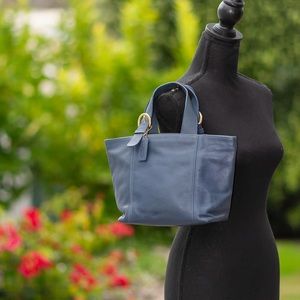 Coach blue leather handbag with gold accent hardware.